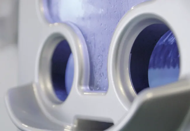 Close-up of the Scrubzone wash chamber's dual UV-lit ports and bristle brush
